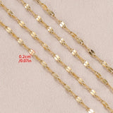 Gold chain with a measurement label on a beige background